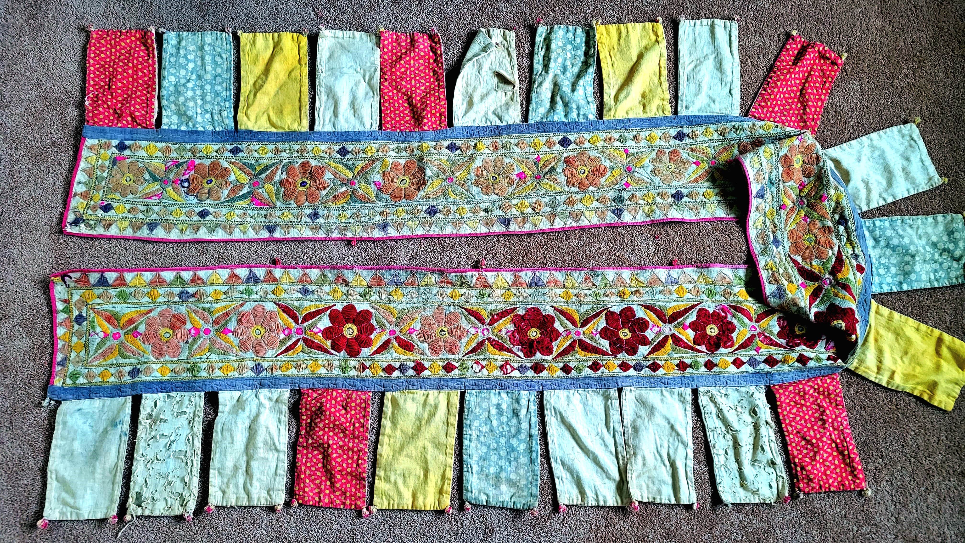 long wall hanging embroidery with flags hanging.